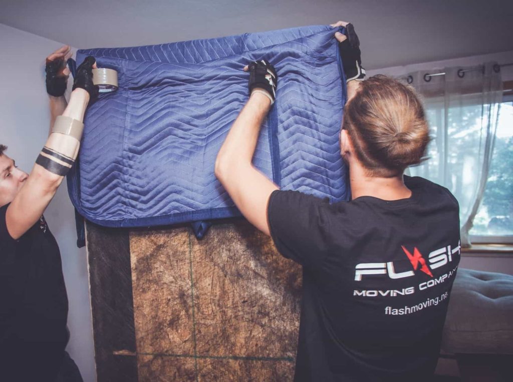 This image shows Flash Moving crew werapping a piece of furniture for a local move.